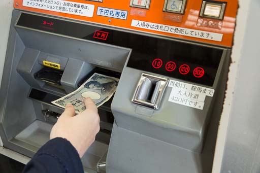 Insert cash into the ticket vending machine