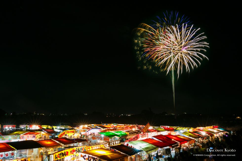 Fireworks over yatai food stalls at the 2015 Kameoka Heiwasai Hozugawa Fireworks Festival.