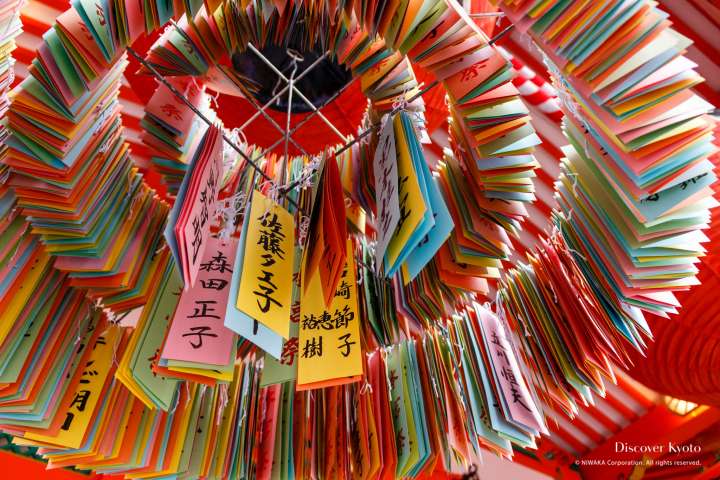 Colorful streamers hanging from a lantern during the Motomiya-sai festival at Fushimi Inari shrine.