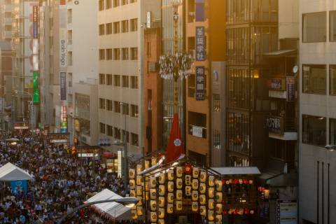 Crowd and float at sunset during the Yoiyama nights of Gion Matsuri.