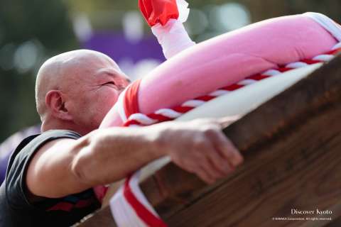 Competitor lifting the rice cake at the Mochi-age at Daigo-ji temple.