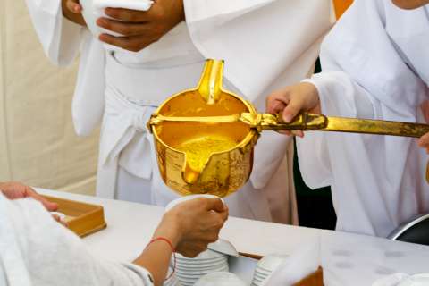 A priestess pours chrysanthemum sake at the Chōyō no Sekku at Kamigamo Jinja.