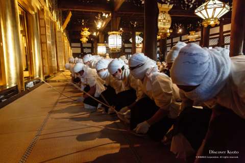 Masked cleaners beating the floor during the Osusuharai at Nishi Hongan-ji.