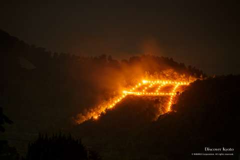 The torii gate shaped ritual fire at the Arashiyama Gozan No Okuribi.
