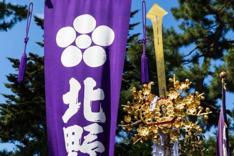 Sacred halberds and a banner held high at the Zuiki Matsuri at Kitano Tenmangū.