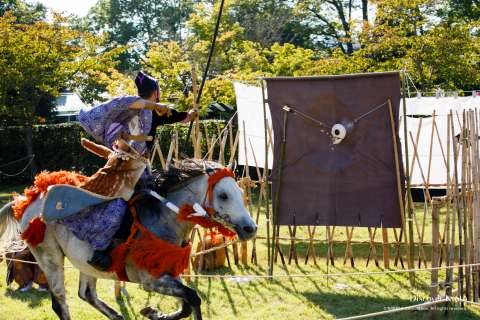 A rider strikes the target at the Kasagake Shinji at Kamigamo Shrine.