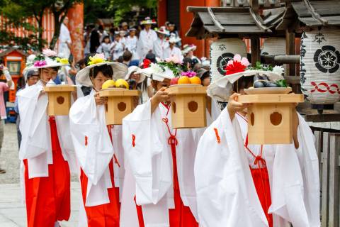 Priestesses carry offerings during the Hanagasa Junkō at Yasaka shrine.