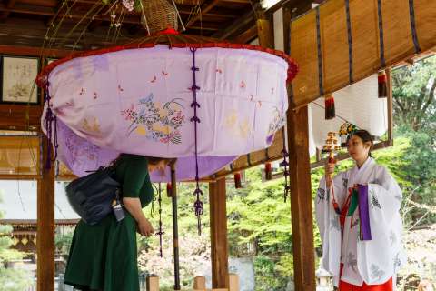 Blessings from a shrine priestess during Yasurai Matsuri at Imamiya Shrine.